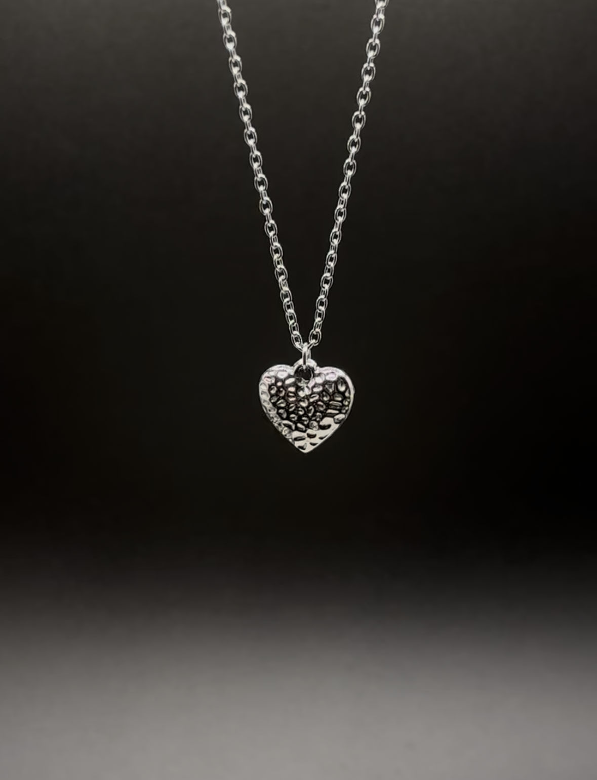 Cyber Heart Collection’s Core Memory necklace — a stainless steel heart pendant with a hammered texture, photographed against a moody gradient backdrop. y2k Jewellery, y2k Jewelry, cyberpunk jewelry, cyber punk jewellery